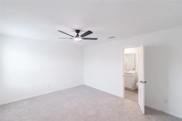 a view of a room with a ceiling fan and bathroom