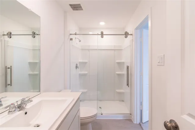 a bathroom with a bathtub shower sink vanity and toilet