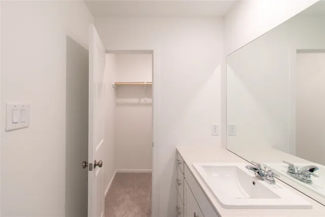 a bathroom with a sink mirror and vanity