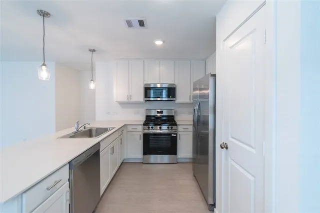a kitchen with stainless steel appliances granite countertop a refrigerator and a sink