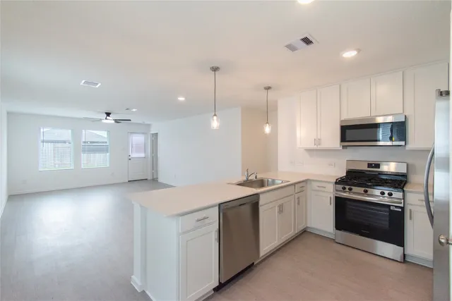 a kitchen with a sink appliances and cabinets