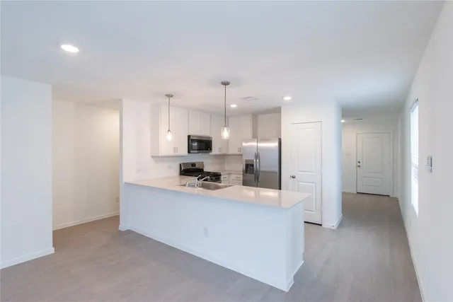 a large kitchen with a lot of counter space and stainless steel appliances