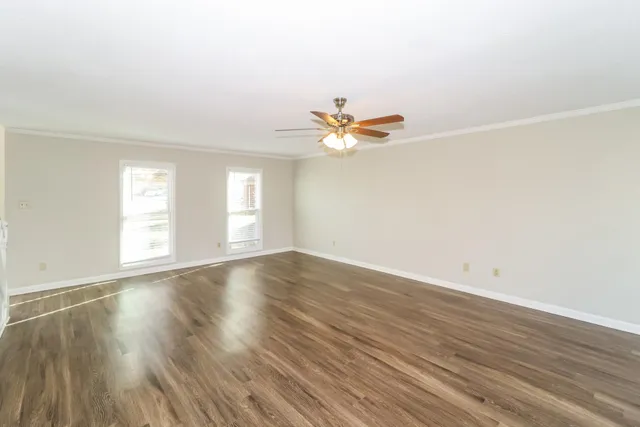 an empty room with wooden floor and window