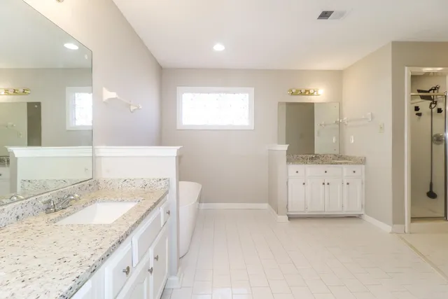 a spacious bathroom with a granite countertop sink and a mirror