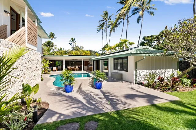 a view of a house with backyard and sitting area