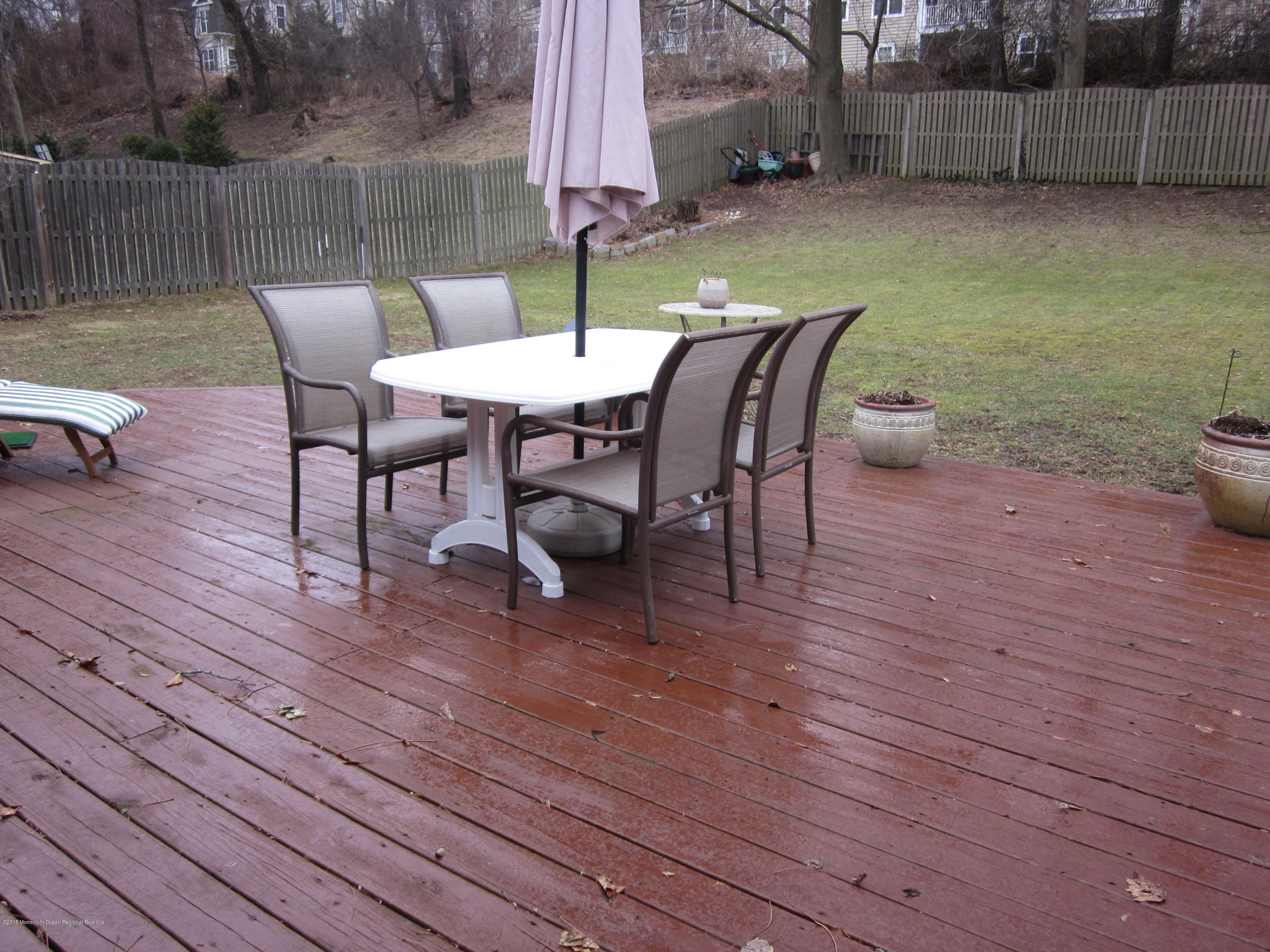 18 Crestview Drive Middletown, NJ 07748 - Photo 18 of 22 a view of a patio with table and chairs with wooden floor