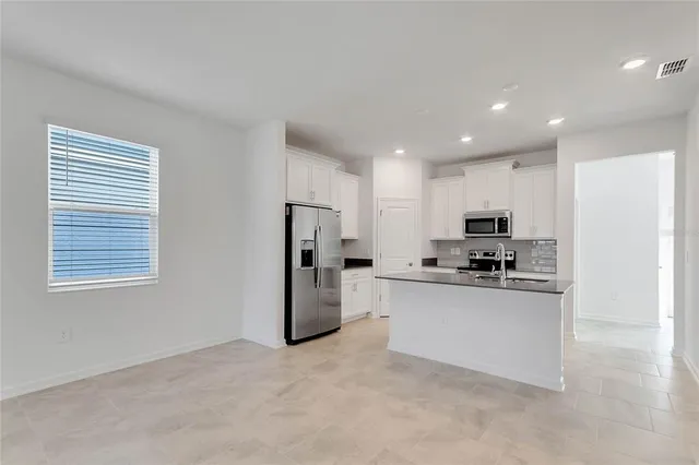 a kitchen with stainless steel appliances a refrigerator a stove a sink a microwave and cabinets