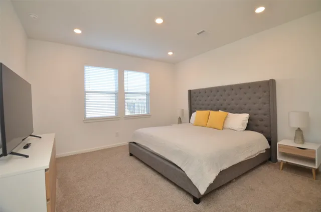 a large bed sitting in a bedroom next to a window
