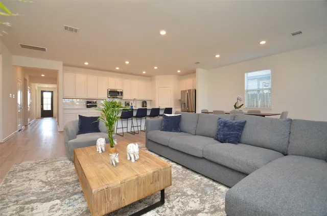 a living room with furniture and a view of kitchen