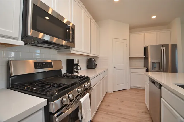 a kitchen with stainless steel appliances granite countertop a stove and a refrigerator