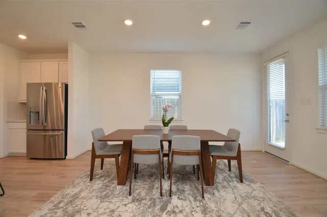 a dining room with furniture and a refrigerator