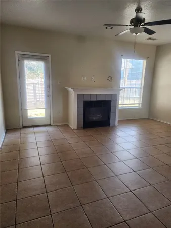 a view of an empty room with a fireplace and a window