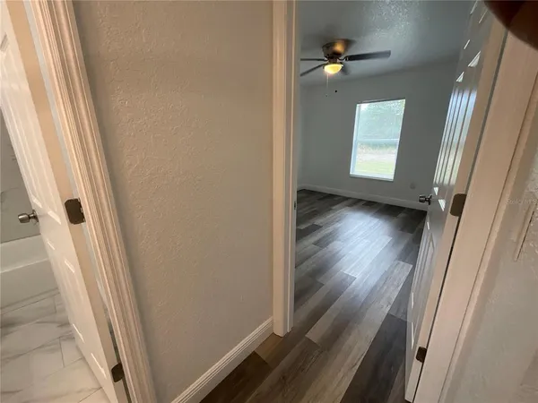 a view of a hallway with wooden floor and stairs