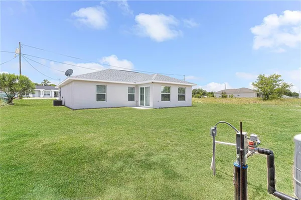 a view of a house with a yard and a fountain