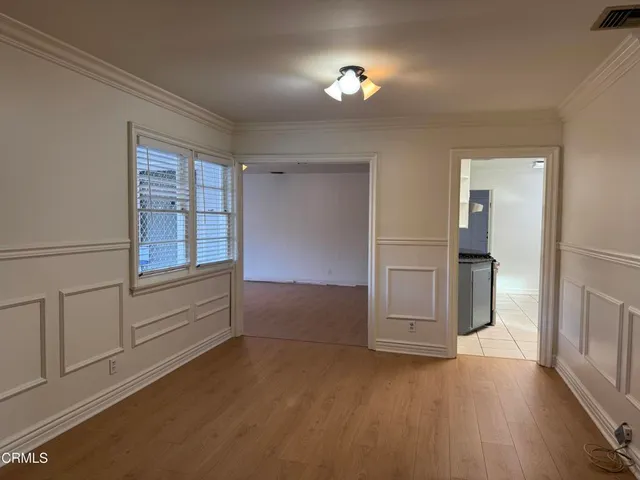 a view of empty room with wooden floor and cabinet