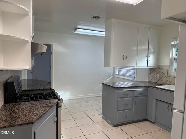 a kitchen with a stove sink and cabinets