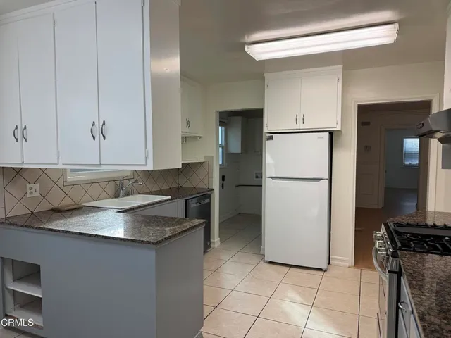 a kitchen with a refrigerator sink and cabinets