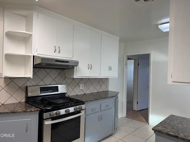 a kitchen with granite countertop a stove and a sink
