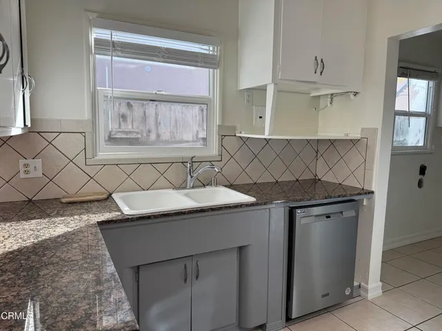 a kitchen with granite countertop a sink and a stove