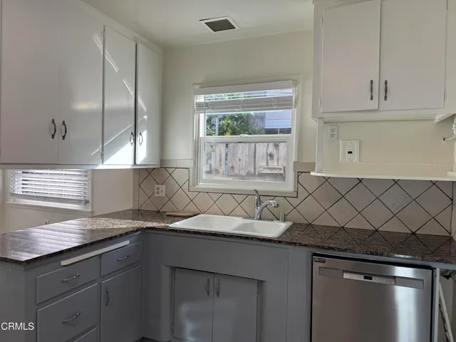 a kitchen with granite countertop a sink and a window
