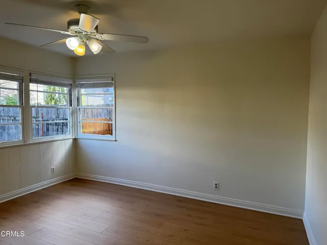an empty room with a window and a fan