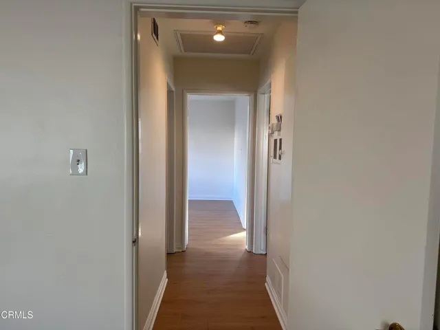 a view of a hallway with wooden shelves
