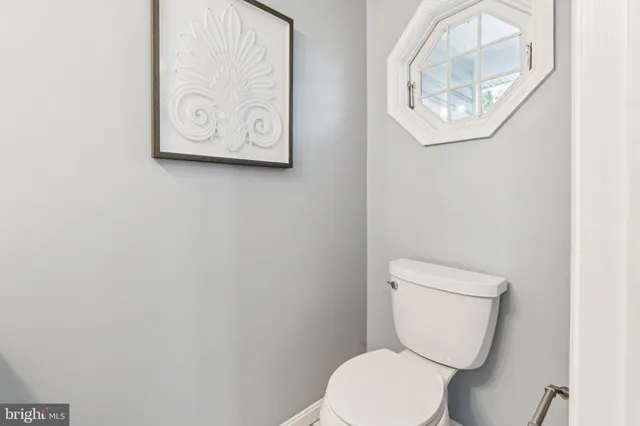 a white toilet sitting next to a white wall