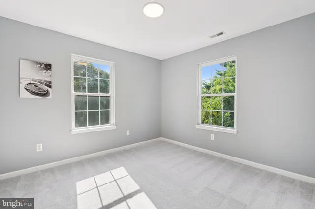 an empty room with windows and closet
