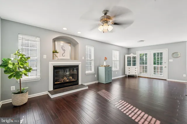 a view of an empty room with wooden floor and a fireplace