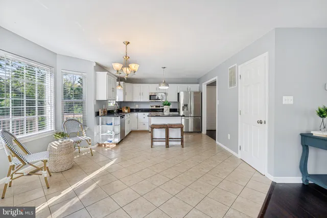 a living room with furniture a dining table and a chandelier