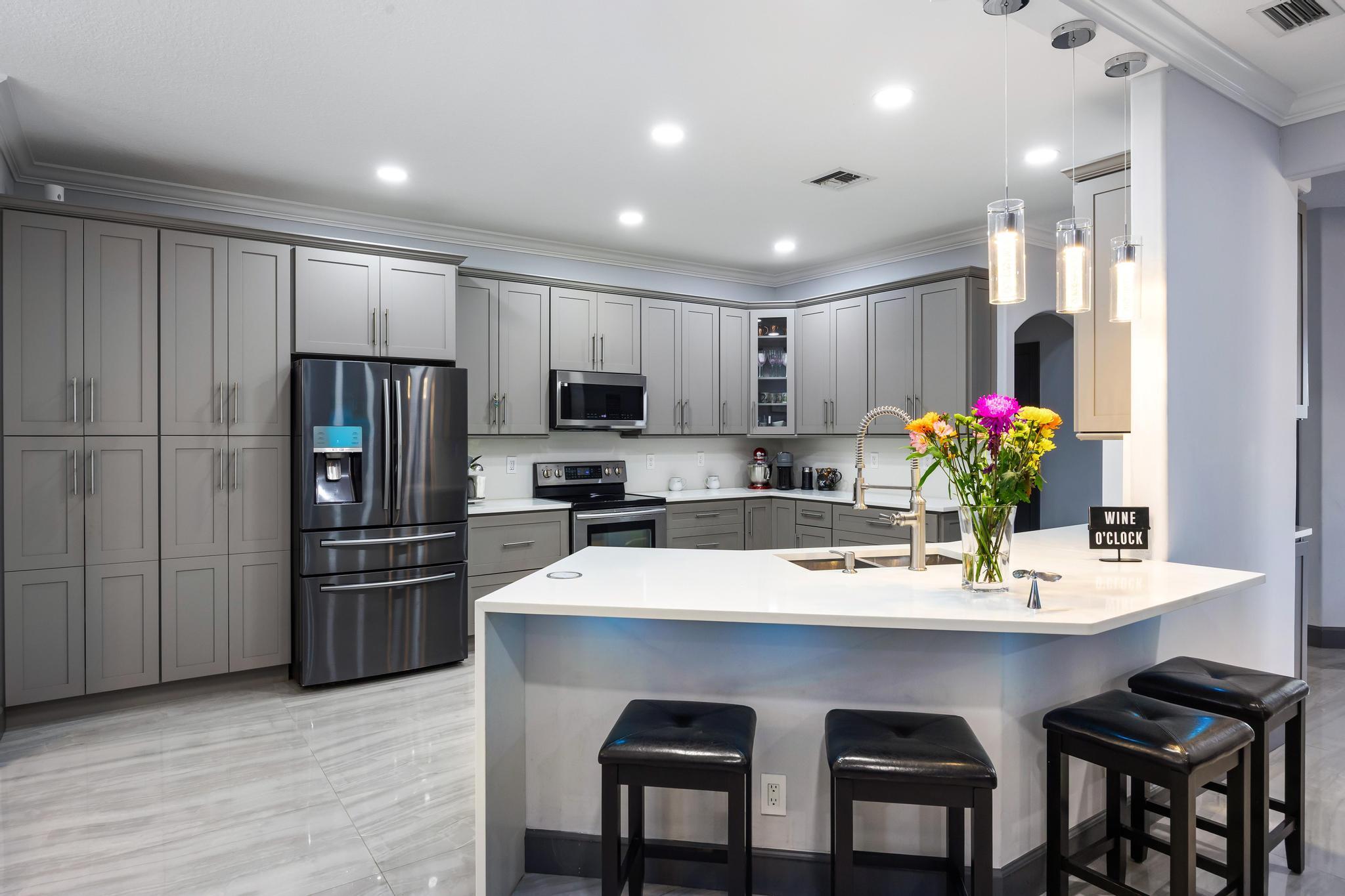 3337 Southwest Crestview Road Port St. Lucie, FL 34953 - Photo 14 of 86 a kitchen with refrigerator cabinets dining table and chairs