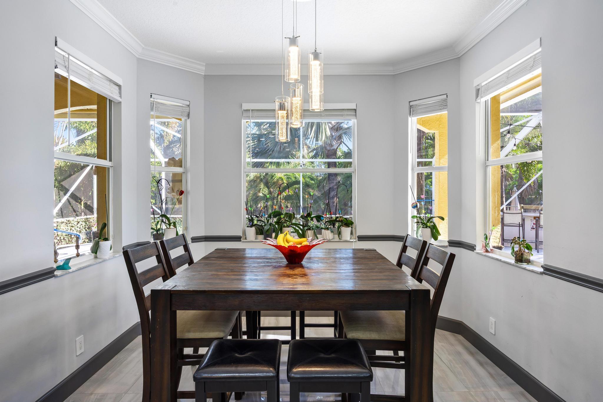 3337 Southwest Crestview Road Port St. Lucie, FL 34953 - Photo 17 of 86 a view of a dining room with furniture a chandelier and wooden floor