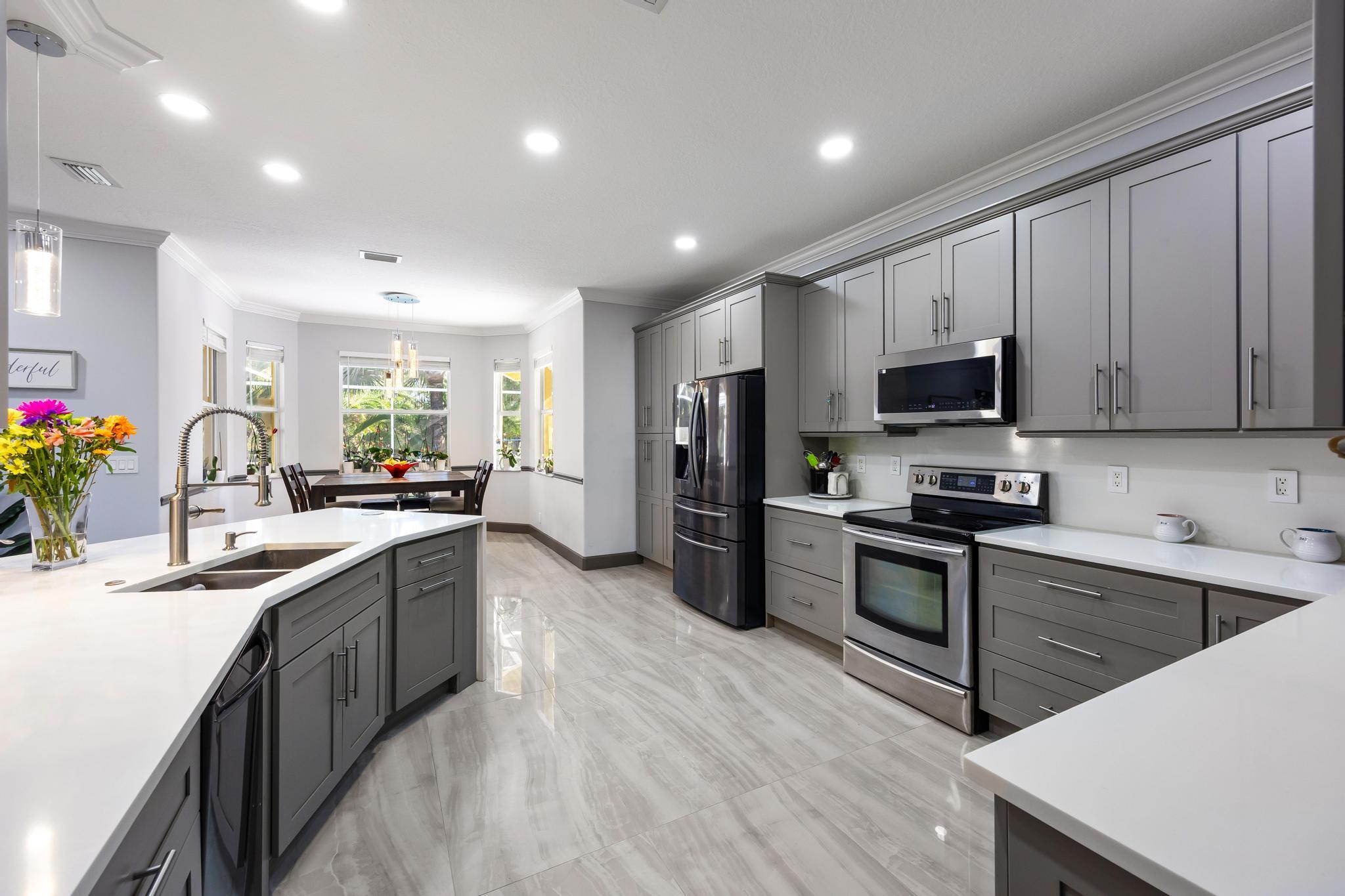 3337 Southwest Crestview Road Port St. Lucie, FL 34953 - Photo 18 of 86 a kitchen with stainless steel appliances a sink dishwasher a stove top oven a refrigerator with wooden floors and cabinets