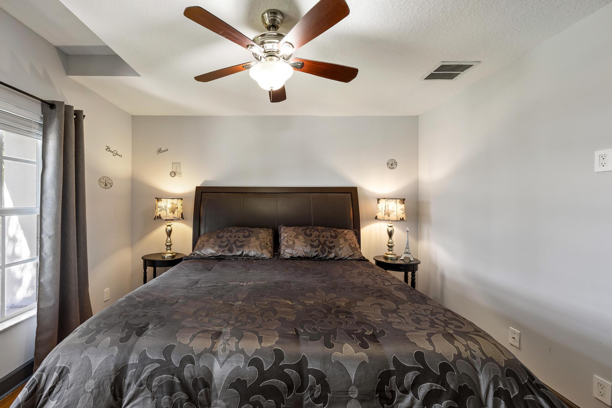 3337 Southwest Crestview Road Port St. Lucie, FL 34953 - Photo 34 of 86 a bedroom with a bed and a chandelier