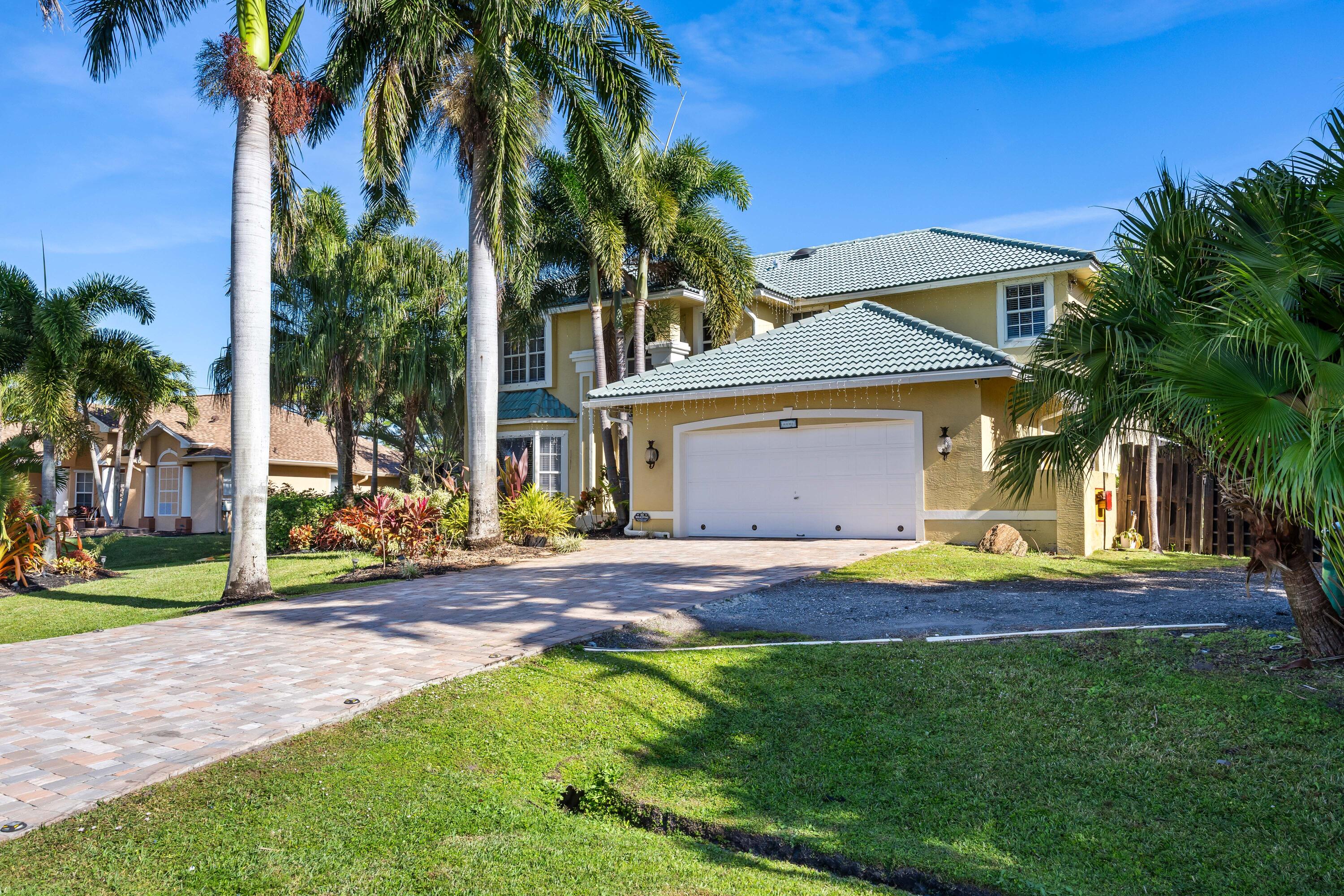 3337 Southwest Crestview Road Port St. Lucie, FL 34953 - Photo 4 of 86 a view of a house with a yard and palm trees