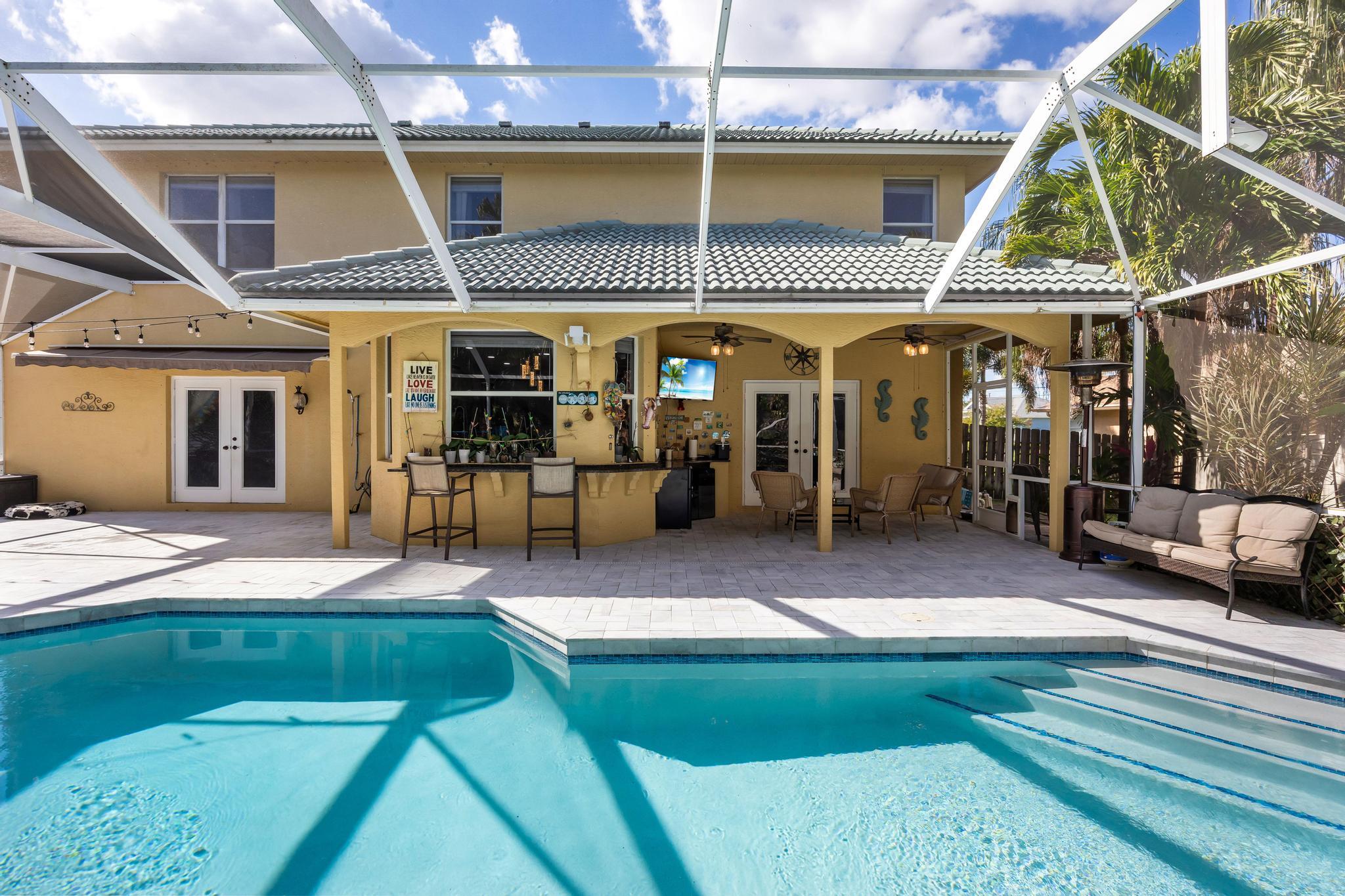 3337 Southwest Crestview Road Port St. Lucie, FL 34953 - Photo 50 of 86 a view of a patio with table and chairs with wooden floor and plants