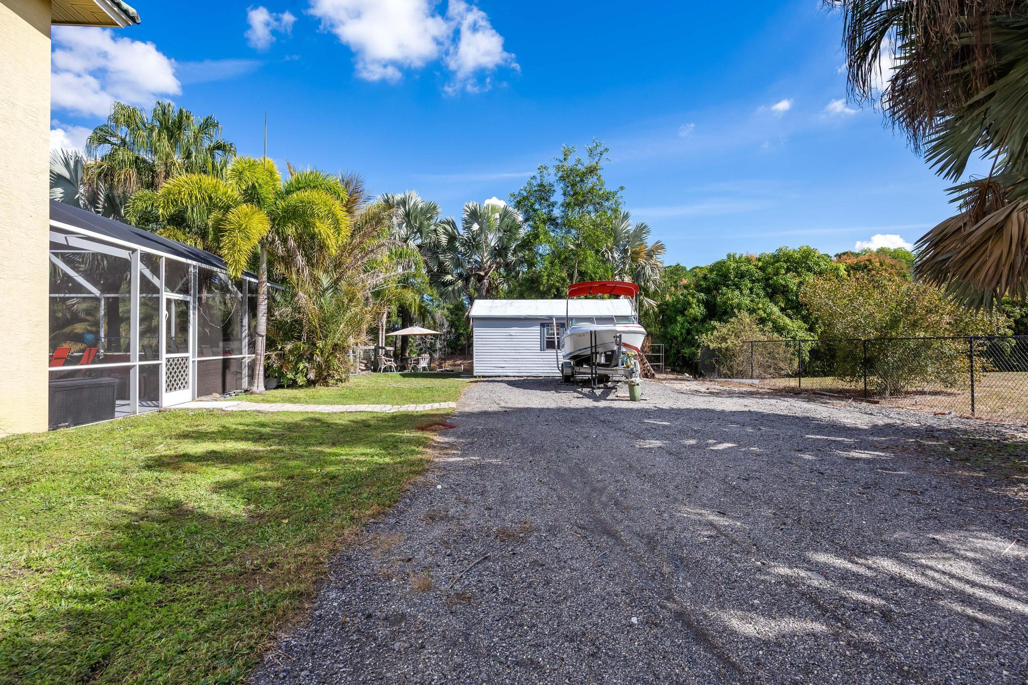 3337 Southwest Crestview Road Port St. Lucie, FL 34953 - Photo 60 of 86 a view of a house with backyard and a tree