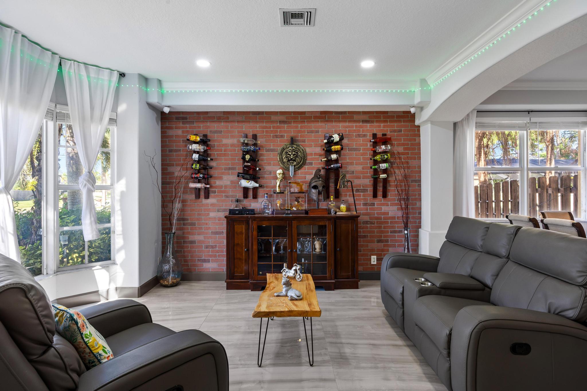 3337 Southwest Crestview Road Port St. Lucie, FL 34953 - Photo 7 of 86 a living room with furniture a fireplace and a large window