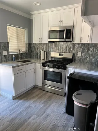 a kitchen with stainless steel appliances a stove a microwave and sink