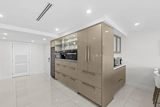 a kitchen with kitchen island granite countertop cabinets and refrigerator