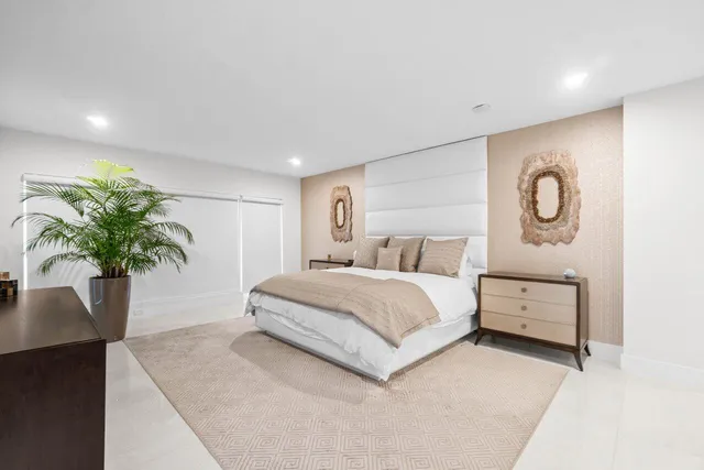 a bedroom with furniture a potted plant and a flat screen tv