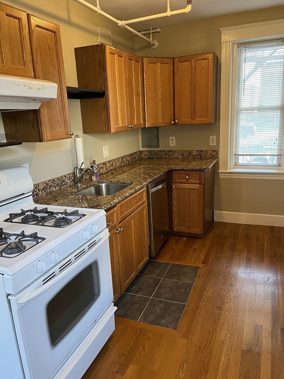 1607 Commonwealth Avenue, Unit 14 Boston, MA 02135 - Photo 3 of 11 a kitchen with a stove a sink and a microwave