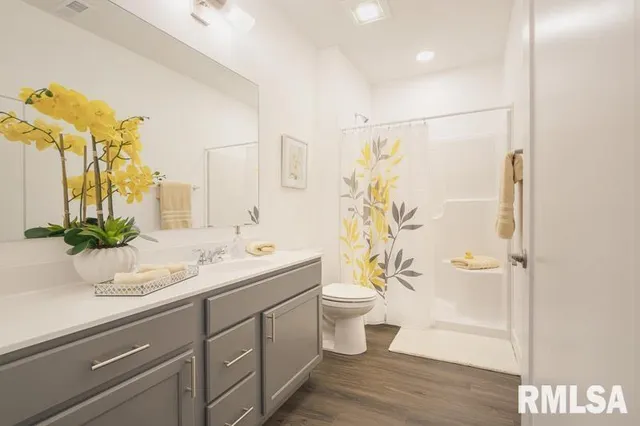 a bathroom with a granite countertop sink toilet and shower