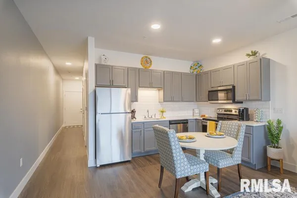 a kitchen with a table chairs refrigerator and microwave