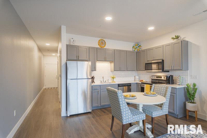 801 Bend Boulevard East Moline, IL 61244 - Photo 4 of 4 a kitchen with a table chairs refrigerator and microwave