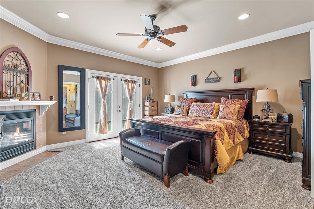 10040 Loveland Court Shreveport, LA 71106 - Photo 15 of 26 a spacious bedroom with a bed and a fireplace