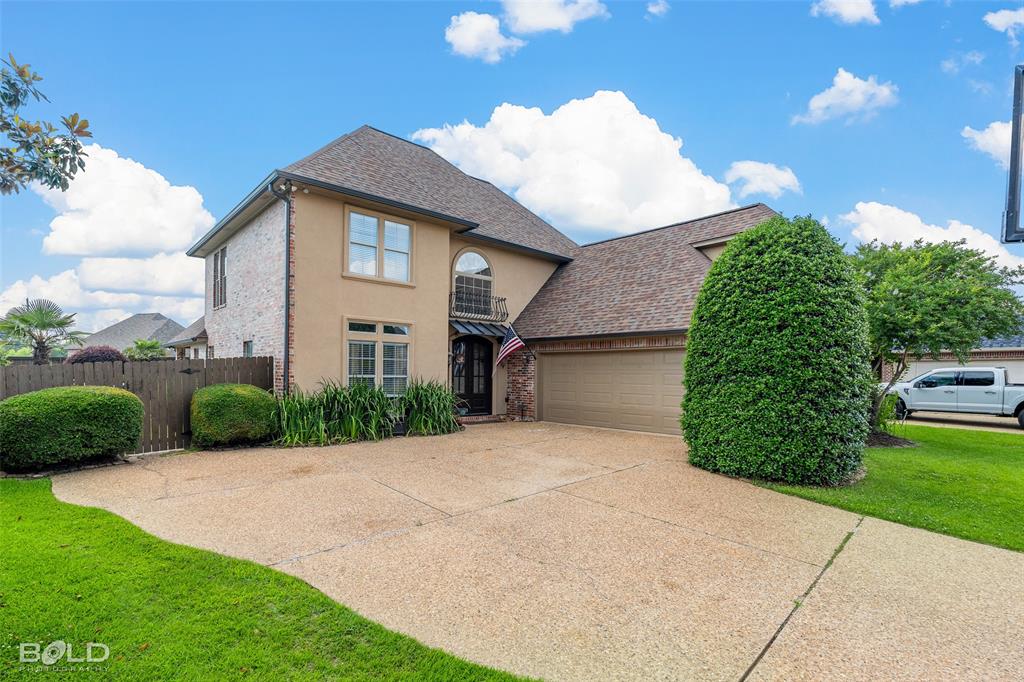 10040 Loveland Court Shreveport, LA 71106 - Photo 2 of 26 a front view of a house with a yard and garage