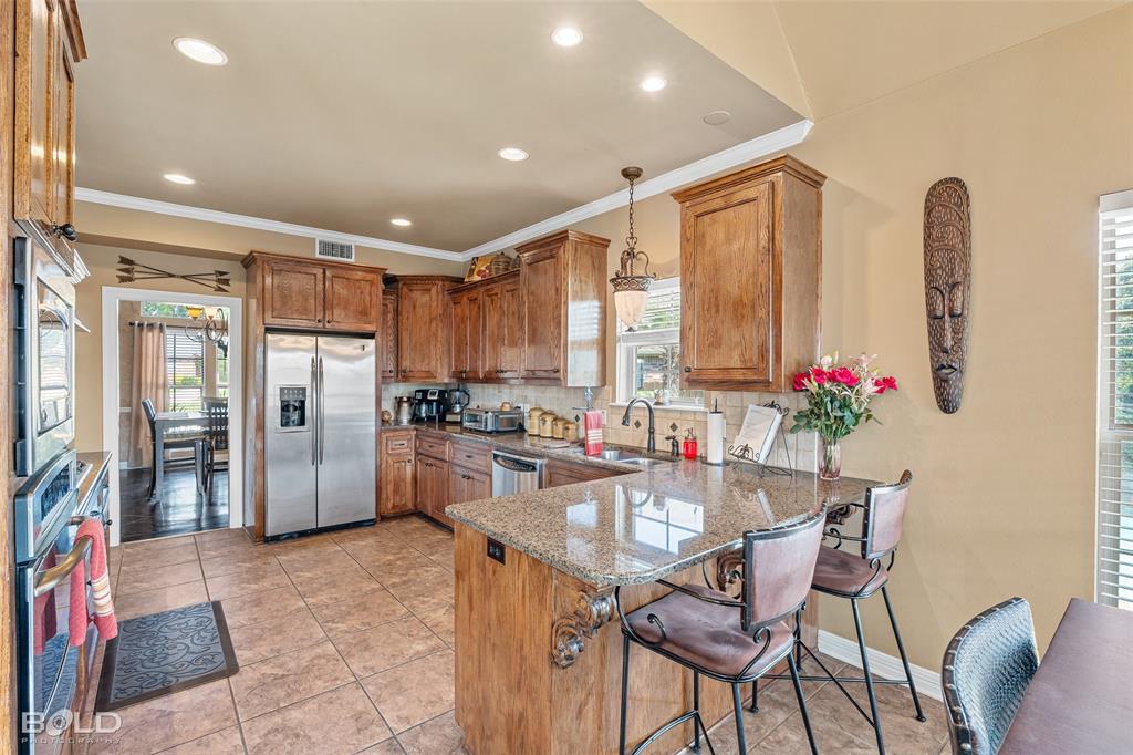 10040 Loveland Court Shreveport, LA 71106 - Photo 10 of 26 a dining hall with stainless steel appliances granite countertop a refrigerator dining table and chairs