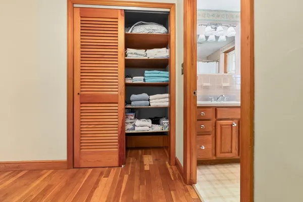 a view of a hallway and a room with wooden floor