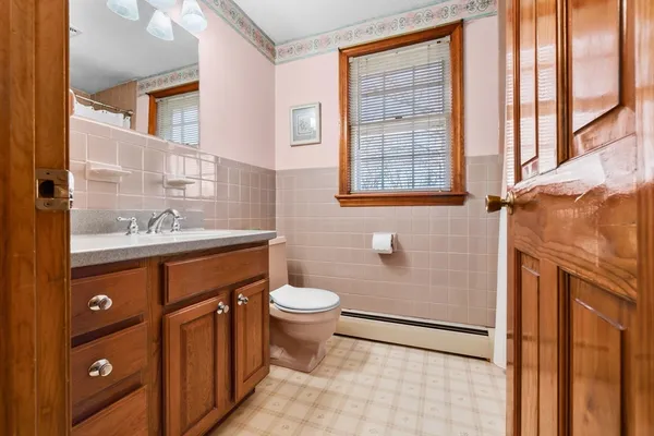 a bathroom with a sink a toilet and a window